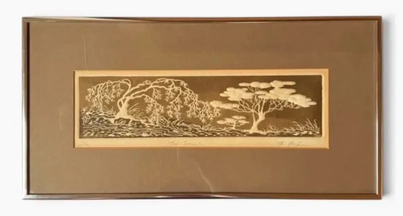 Framed landscape print by Al Kaufman titled “Tree Scene,” showing a wooded outdoor setting rendered in Kaufman’s characteristic printmaking style, with trees dominating the composition and layered landscape forms receding into the background.
